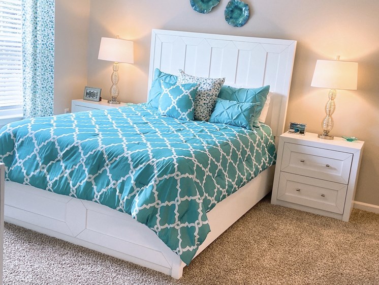 furnished master bedroom in a Fayetteville apartment with plush carpeting